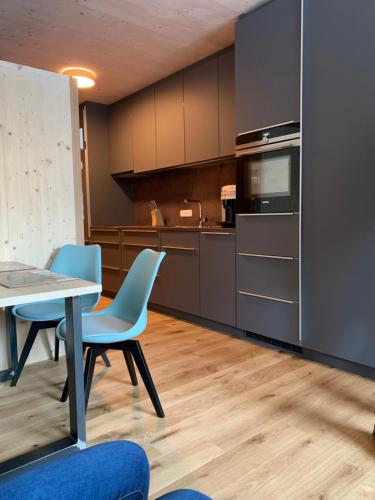 a kitchen with a table and two chairs and a table and a counter at Apartment Almwiesen Mellau in Mellau