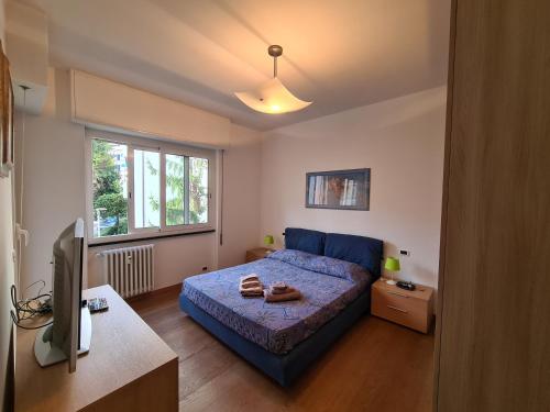 a bedroom with a blue bed and a television at La Casa di Riki by PortofinoVacanze in Rapallo