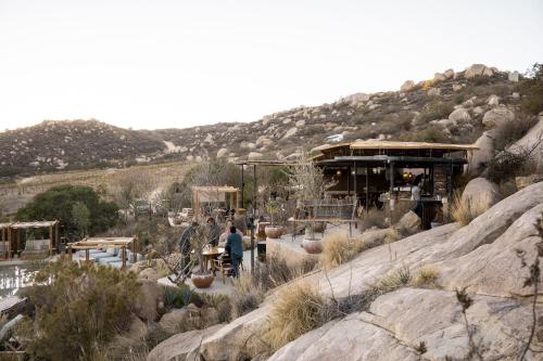 a person standing in front of a building on a mountain at Encuentro Guadalupe in Valle de Guadalupe