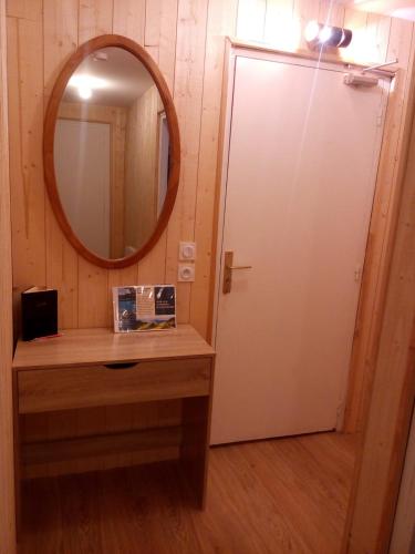 a bathroom with a mirror and a sink and a door at Champeix, maison confort 6 personnes in Champeix