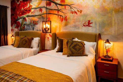 a bedroom with two beds and a painting on the wall at Hotel Boutique Madre Tierra in Mazunte