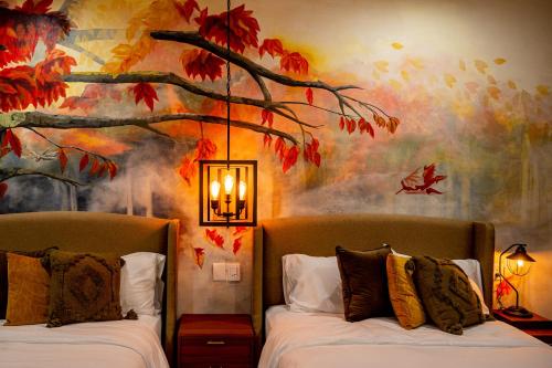 a bedroom with two beds with a painting on the wall at Hotel Boutique Madre Tierra in Mazunte