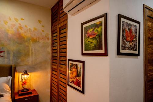 a bedroom with paintings on the wall and a bed at Hotel Boutique Madre Tierra in Mazunte