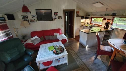 a living room with a red couch and a table at Lille Hus in Gartow