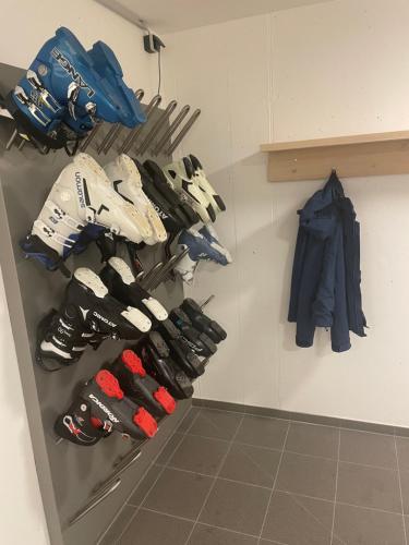 a rack of shoes and umbrellas on a wall at Wasserfall Apartments Mellau in Mellau