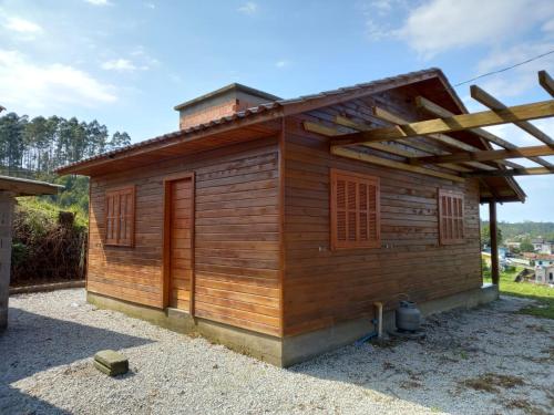 a wooden cabin with a roof at Pousada Encantos Da Montanha in Louro Müller
