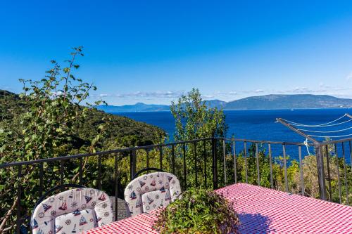 a table and chairs with a view of the ocean at Apartmani Valun1 in Valun