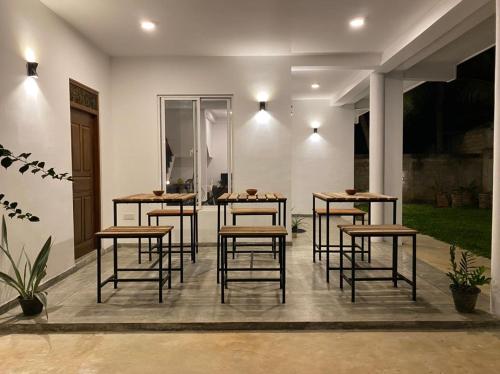 eine Gruppe von Tischen und Stühlen auf einer Terrasse in der Unterkunft Kalan Mirissa in Mirissa