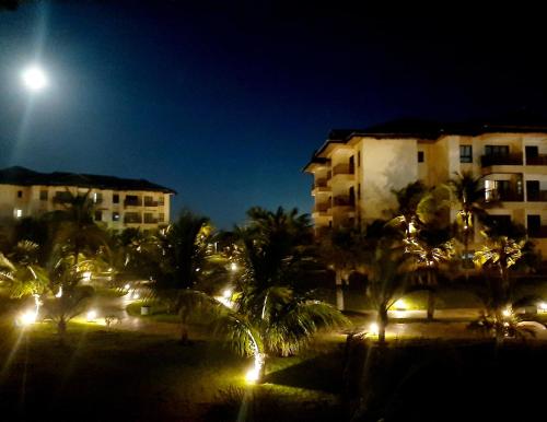 a night view of buildings with palm trees and a street light at VG SUN CUMBUCO-Lake Flat C1 201 1 a 4 pessoas in Caucaia