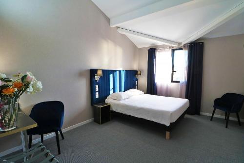 - une chambre avec un lit, deux chaises et une table dans l'établissement Hôtel Napoléon, à La Turbie