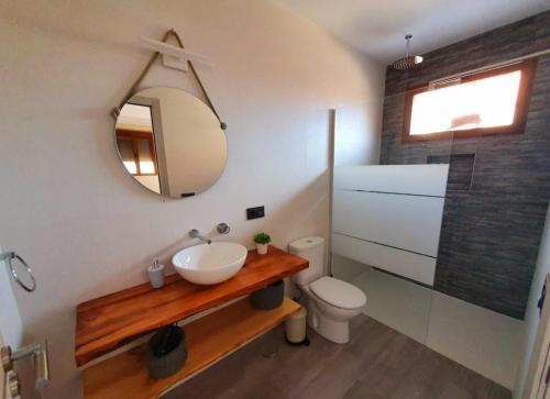 a bathroom with a sink and a toilet and a mirror at Acogedora casa rural con piscina particularBarlow in Abadía