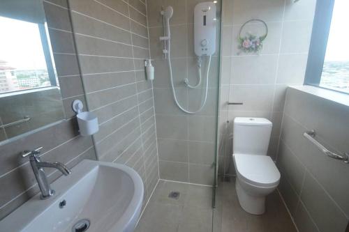 a bathroom with a shower and a toilet and a sink at KOZI Square New SGH Cozy Home LV7B in Kuching