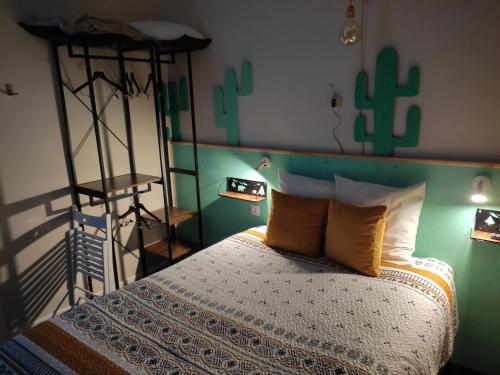 1 dormitorio con 1 cama con cabecero de cactus en Hôtel Confort 09 ou HC-09, en Tarascon-sur-Ariège