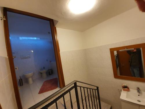a bathroom with a toilet and a sink and a mirror at Casa Mirella in Lovere