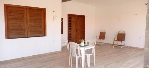 Habitación con mesa, sillas y puerta de madera. en Casa Tropicana en Flecheiras