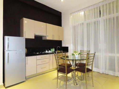 a kitchen with a table and chairs and a refrigerator at VIVAS Residencies Luxury Apartments in Colombo