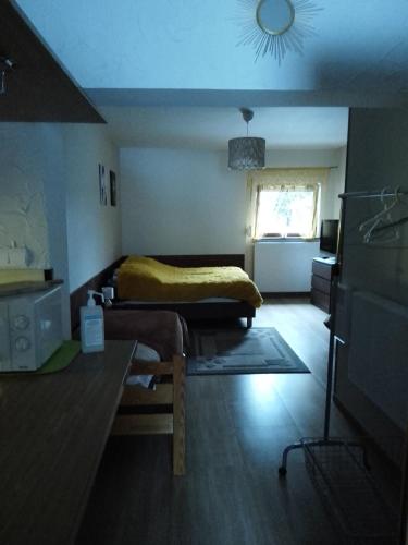 a bedroom with a bed and a table and a window at Willa Gracja in Wisła