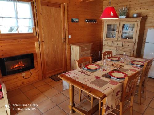 a dining room with a table and a fireplace at Chalet Le Cambre d'Aze in Font-Romeu