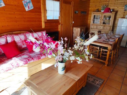 a living room with a couch and a table with flowers at Chalet Le Cambre d'Aze in Font-Romeu