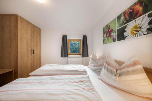 a bedroom with two beds and a wooden cabinet at Gfliererhof in Fiè