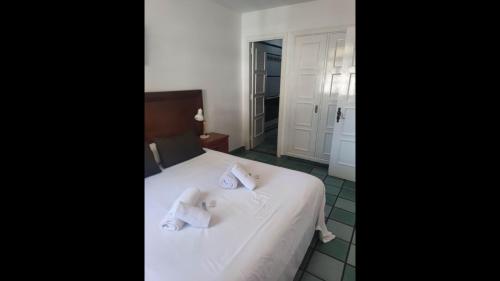 a bedroom with a white bed with towels on it at First Line Luxury Apartment by El Sirocco in Puerto de Mogán