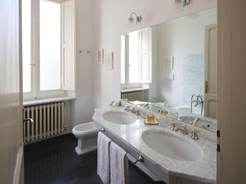 a white bathroom with two sinks and a toilet at Villa Monacelli in Fano