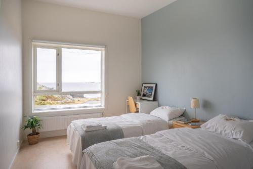 um quarto branco com 2 camas e uma janela em Runde Miljøsenter & Opplev Runde em Runde
