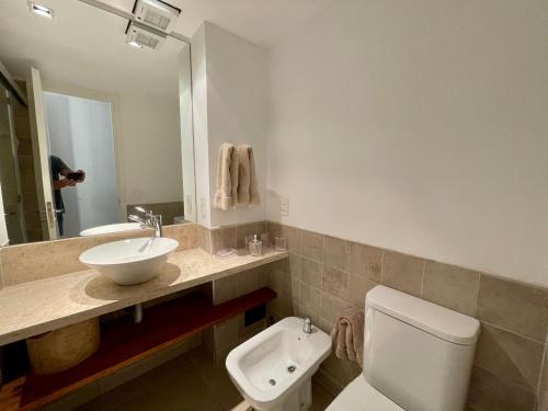 a bathroom with a toilet and a sink and a mirror at Quartier Punta Ballena 2 dorm en suite in Punta del Este