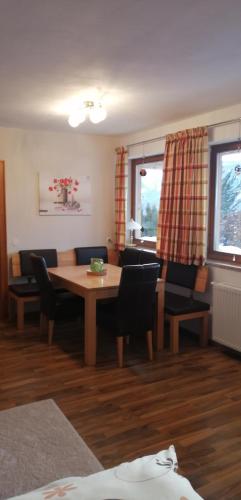 a living room with a wooden table and chairs at Haus Jessica incl National Park Sommercard in Mittersill
