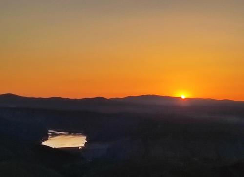 a sunset over a body of water with the sun in the background at CASA RURAL EL CAIDERÓN in Ambel