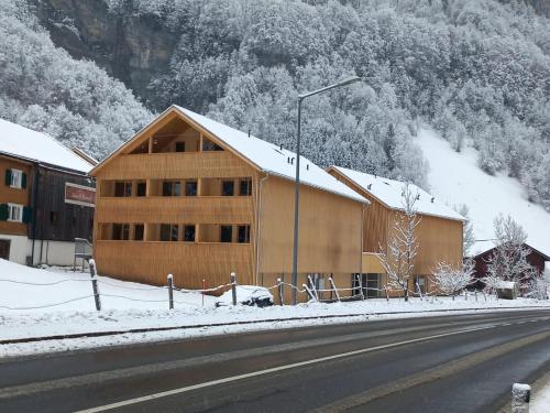 a building on the side of a road with snow at Apartment Almwiesen Mellau in Mellau