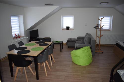 a living room with a table and chairs and a couch at Penzion Víra in Velké Losiny