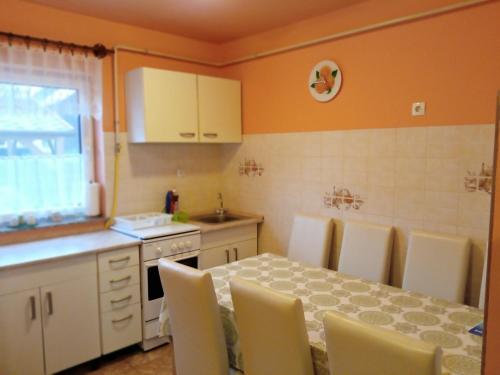 een keuken met een tafel en stoelen en een keuken met een wastafel bij Éva vendégház Guesthouse in Hajdúszoboszló
