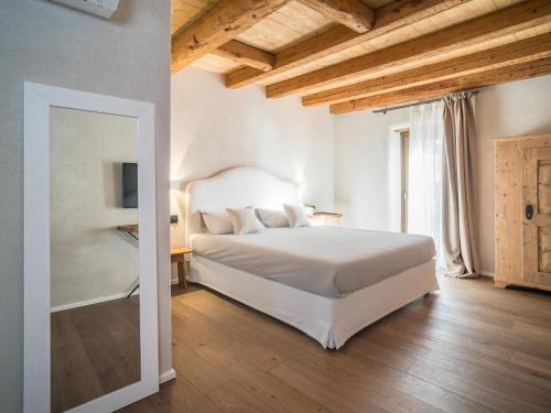een slaapkamer met een groot wit bed en een spiegel bij Borgo San Verolo B&B in Castion Veronese