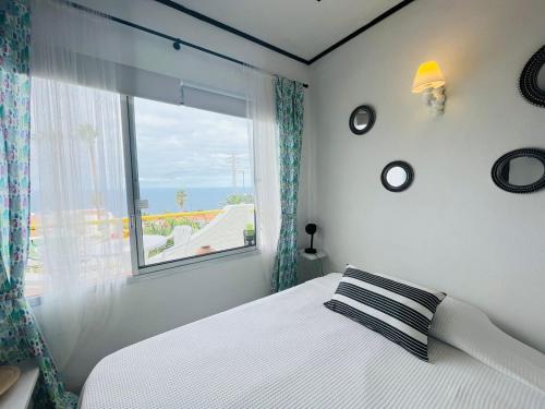 - une chambre avec un lit et une grande fenêtre dans l'établissement Studio sea front view & pool, à Tacoronte