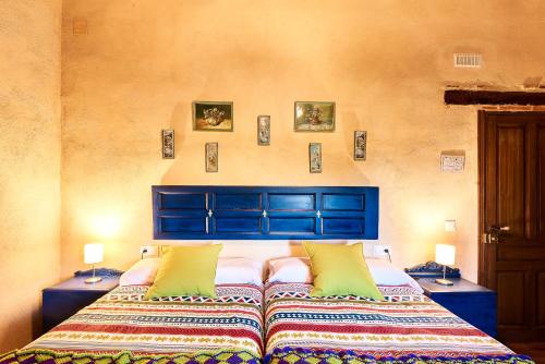 een slaapkamer met een bed met een blauw hoofdeinde bij Casa Rural Sierra Jayona in Fuente del Arco