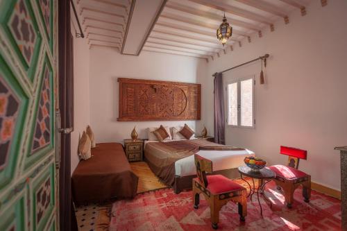 1 dormitorio con 2 camas, mesa y sillas en Dar Halima, en Marrakech