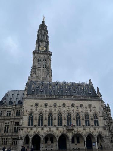 a building with a clock tower on top of it at Superbe appartement en Centre ville d'ARRAS in Arras
