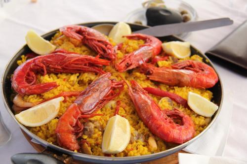 a bowl of shrimp and rice with lemon slices at Hotel Vasco Da Gama in Monte Gordo