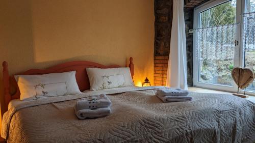 a bedroom with a large bed with towels on it at WeisseVilla Friedrichsbrunn Fewo SOLIDE in Thale