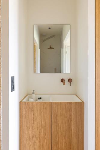 une salle de bain avec un lavabo et un miroir dans l'établissement Château de Callac, à Illats