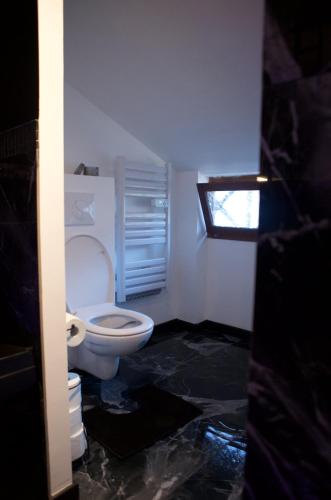 a bathroom with a white toilet in a room at PARENTHESE LOVE - Amour & Tentation Suite Balnéo SPA Proche Orly-Paris in La Ville-du-Bois