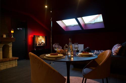 a dining room with a table and chairs and skylights at PARENTHESE LOVE - Amour & Tentation Suite Balnéo SPA Proche Orly-Paris in La Ville-du-Bois