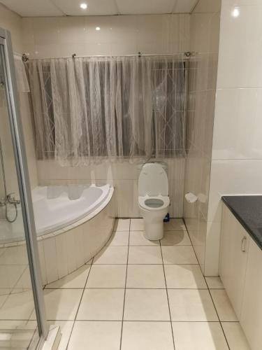 a bathroom with a toilet and a tub and a sink at 26 Zea avenue Arcon Park Guest House in Vereeniging