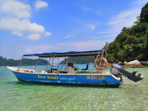 a blue boat sitting in the water in the ocean at 48 悠之处NO . 48, PERSIARAN ALAM IMPIAN 3 VILLA RIADAH ALAM IMPIAN PANGKOR, 32300 PANGKOR , PERAK. in Pangkor
