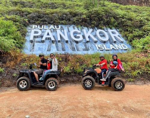 a group of people riding on atvs in front of a sign at 48 悠之处NO . 48, PERSIARAN ALAM IMPIAN 3 VILLA RIADAH ALAM IMPIAN PANGKOR, 32300 PANGKOR , PERAK. in Pangkor