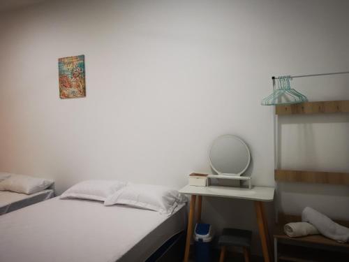 a bedroom with two beds and a mirror and a table at 48 悠之处NO . 48, PERSIARAN ALAM IMPIAN 3 VILLA RIADAH ALAM IMPIAN PANGKOR, 32300 PANGKOR , PERAK. in Pangkor