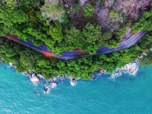 an aerial view of a road in a forest next to the water at 48 悠之处NO . 48, PERSIARAN ALAM IMPIAN 3 VILLA RIADAH ALAM IMPIAN PANGKOR, 32300 PANGKOR , PERAK. in Pangkor