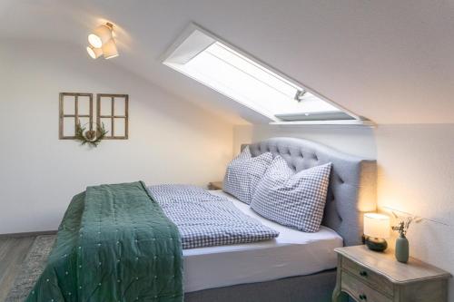 a bedroom with a bed and a skylight at Sonnig, Balkon, Berge & im Herzen von Sonthofen in Sonthofen