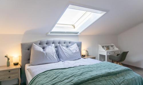 a bedroom with a large bed with a skylight at Sonnig, Balkon, Berge & im Herzen von Sonthofen JS1 in Sonthofen